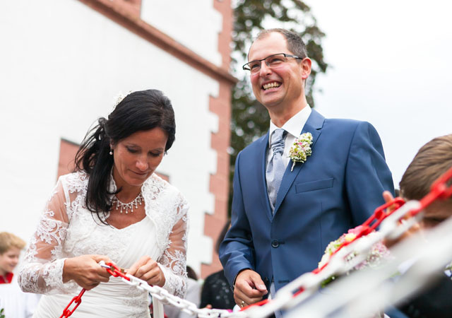 Dynamische Weitwinkelaufnahme aus Hochzeitsfotografie Reportage eines Paares das gerade ein Schloss öffnet
