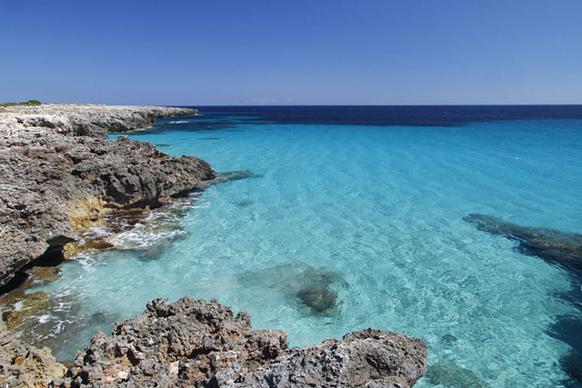 Meeresbucht mit Sand am Meeresgrund und türkisblauem Wasser in der Nähe der Höhle Cova dels Pardals bei Son Xoriguer, Menorca, Spanien